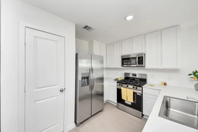 a kitchen with stainless steel appliances and white cabinets