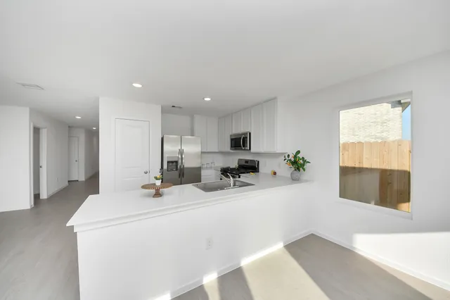 a kitchen with stainless steel appliances a sink stove and cabinets