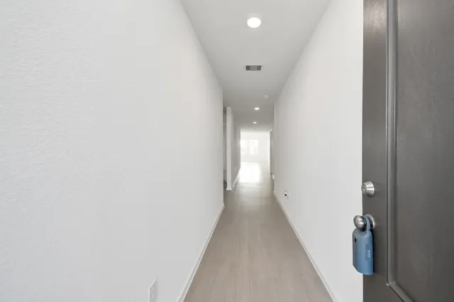 a view of a hallway with wooden floor