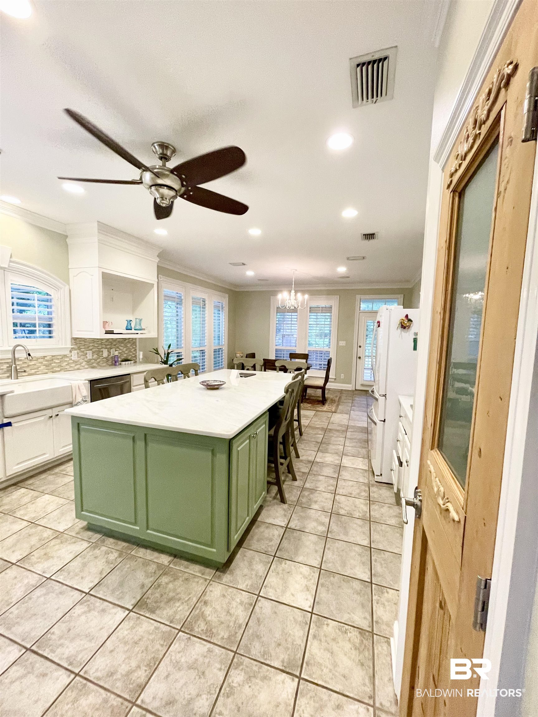 202 Potters Mills Road Daphne, AL 36526 - Photo 9 of 29 Kitchen featuring ceiling fan with notable chandelier, white cabinets, a center island, green cabinetry, and light tile patterned floors