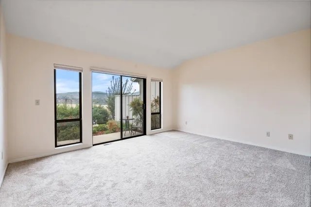 an empty room with sliding glass door and balcony