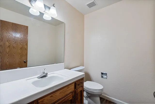 a bathroom with a sink a toilet and a mirror