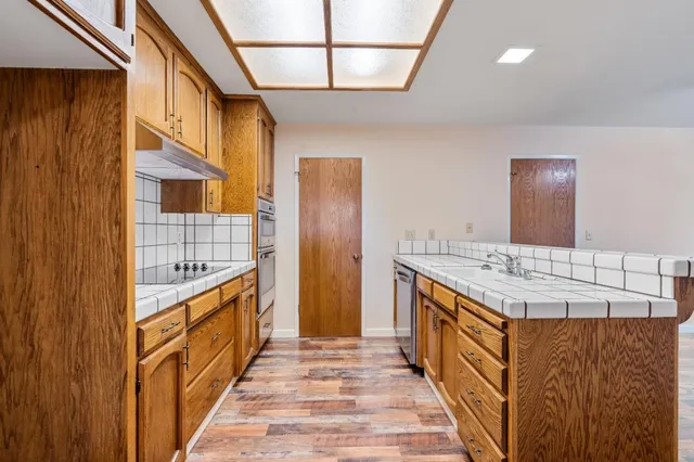 a kitchen with stainless steel appliances granite countertop a sink and stove top oven
