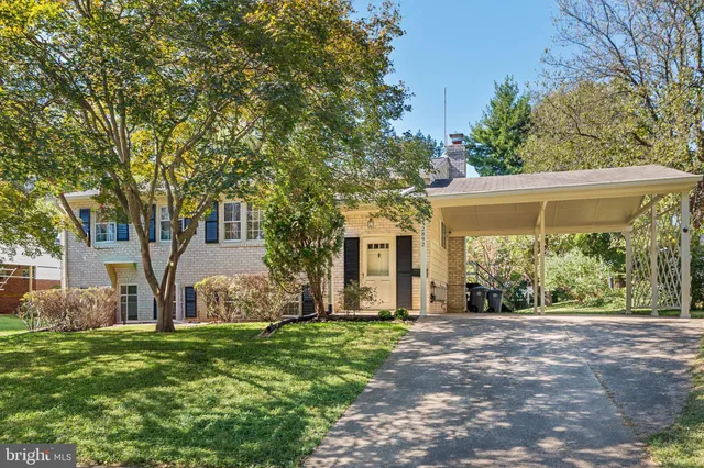 a view of a house with backyard and a tree