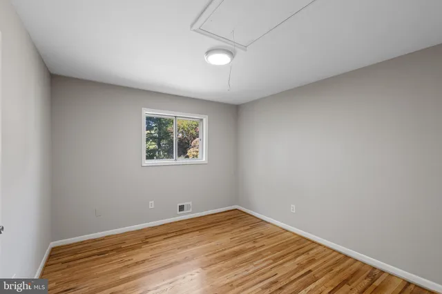 a view of a room with wooden floor and window