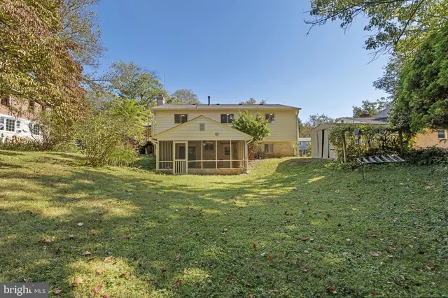 a view of a big house with a big yard and large trees