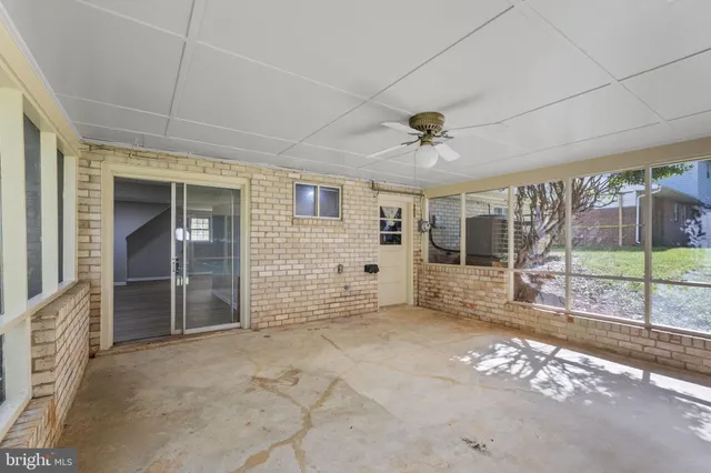 a view of a porch with furniture and floor to ceiling window