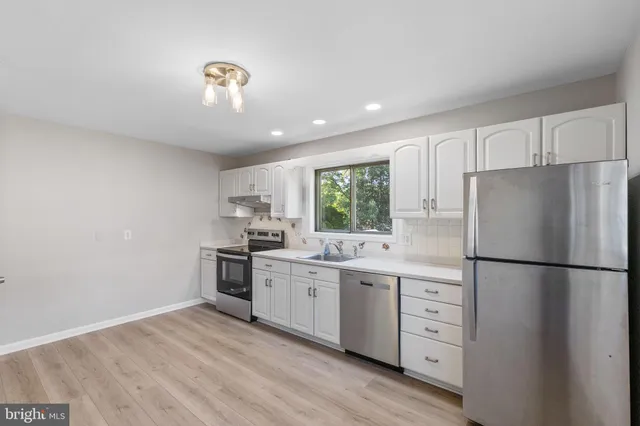 a kitchen with stainless steel appliances granite countertop a refrigerator sink and stove