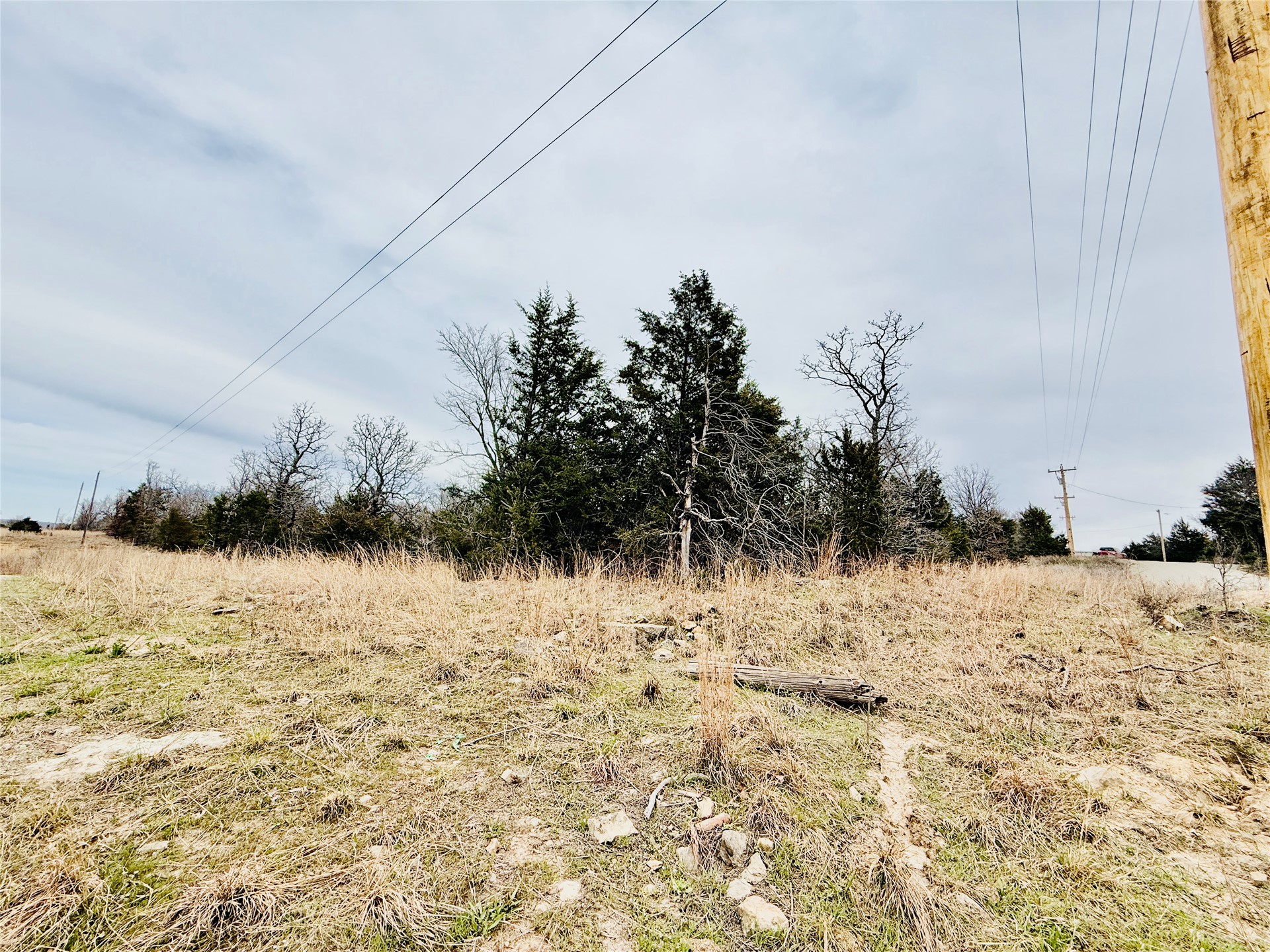 0 Dozer Mountain Road Eufaula, OK 74432 - Photo 5 of 7 Expansive land parcel featuring natural terrain, mature trees, and overhead utility lines