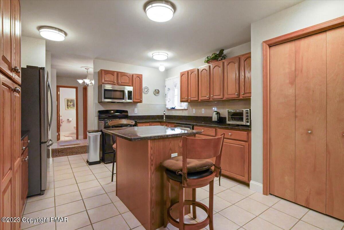 105 Alford Court Bushkill, PA 18324 - Photo 19 of 64 a kitchen with stainless steel appliances granite countertop a stove a sink and a refrigerator