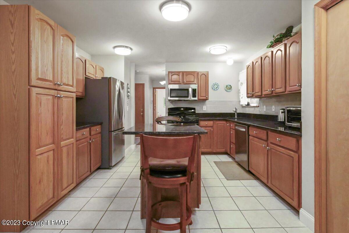 105 Alford Court Bushkill, PA 18324 - Photo 20 of 64 a kitchen with stainless steel appliances granite countertop a refrigerator sink and cabinets