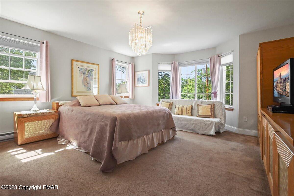 105 Alford Court Bushkill, PA 18324 - Photo 24 of 64 a spacious bedroom with a bed and a flat tv screen on dresser