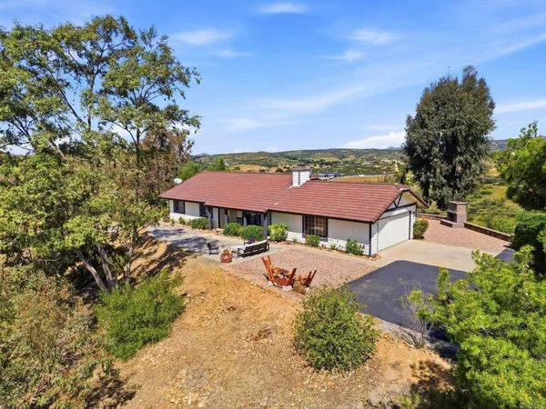 an aerial view of a house with garden space and trees