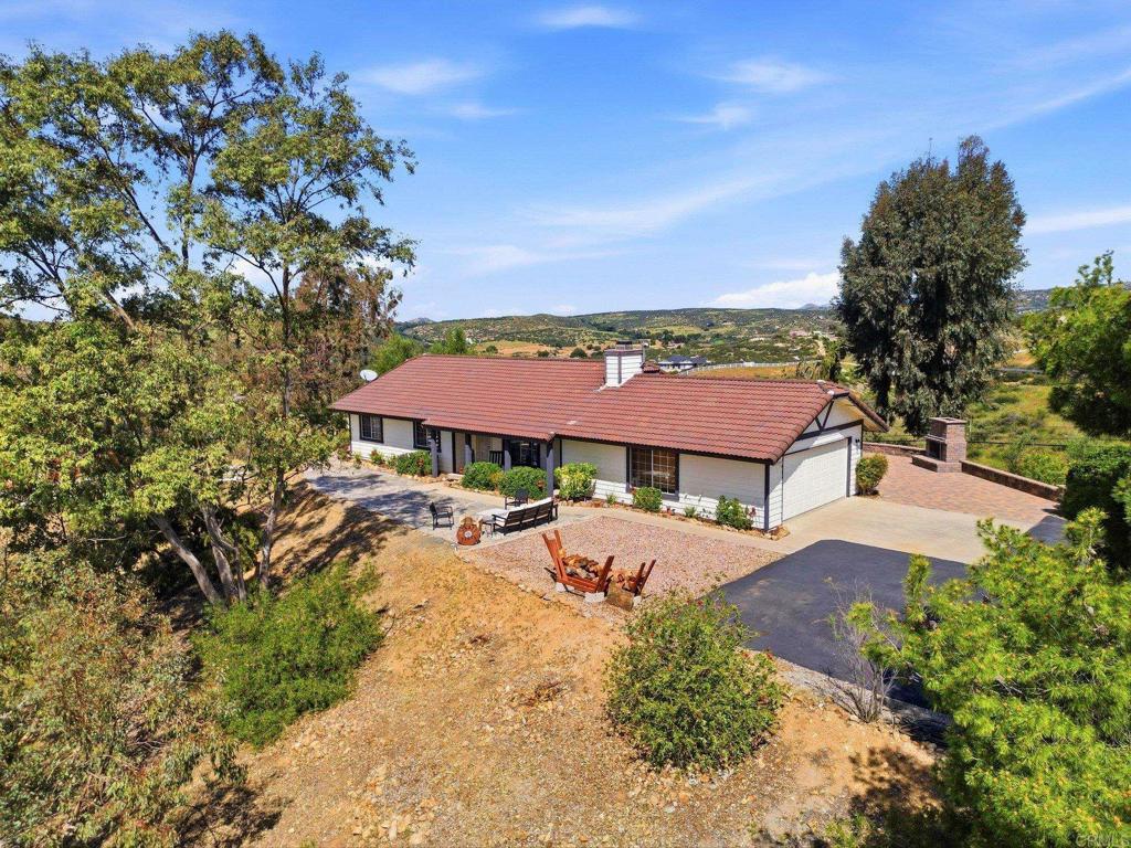an aerial view of a house with garden space and trees