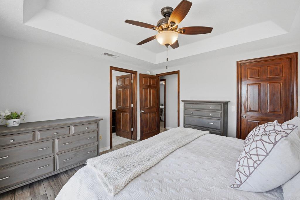 37875 Sage Road Hemet, CA 92544 - Photo 14 of 33 a bedroom with a large bed and a chandelier