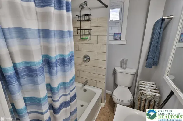a bathroom with a toilet and a shower curtain