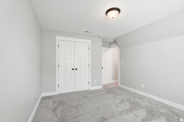 338 Windy Rdg Drive Smithfield, UT 84335 - Photo 43 of 63 Spacious room featuring light gray wall paint, white trim, gray carpet flooring, a ceiling-mounted light fixture, and double white paneled doors