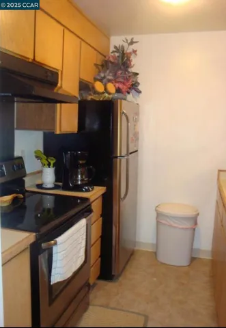 a kitchen with stainless steel appliances granite countertop a sink a stove a refrigerator and a microwave