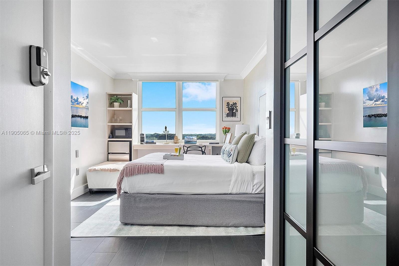 2889 McFarlane Road, Unit 902 Miami, FL 33133 - Photo 28 of 62 a bedroom with a bed large window and a potted plant