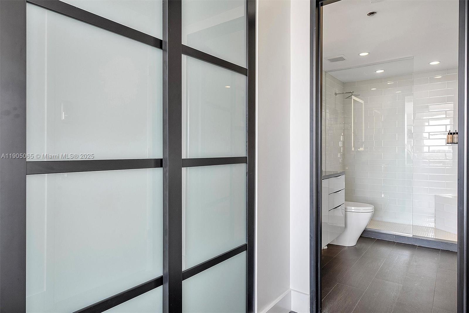 2889 McFarlane Road, Unit 902 Miami, FL 33133 - Photo 29 of 62 a view of a bathroom with a glass door and a glass door