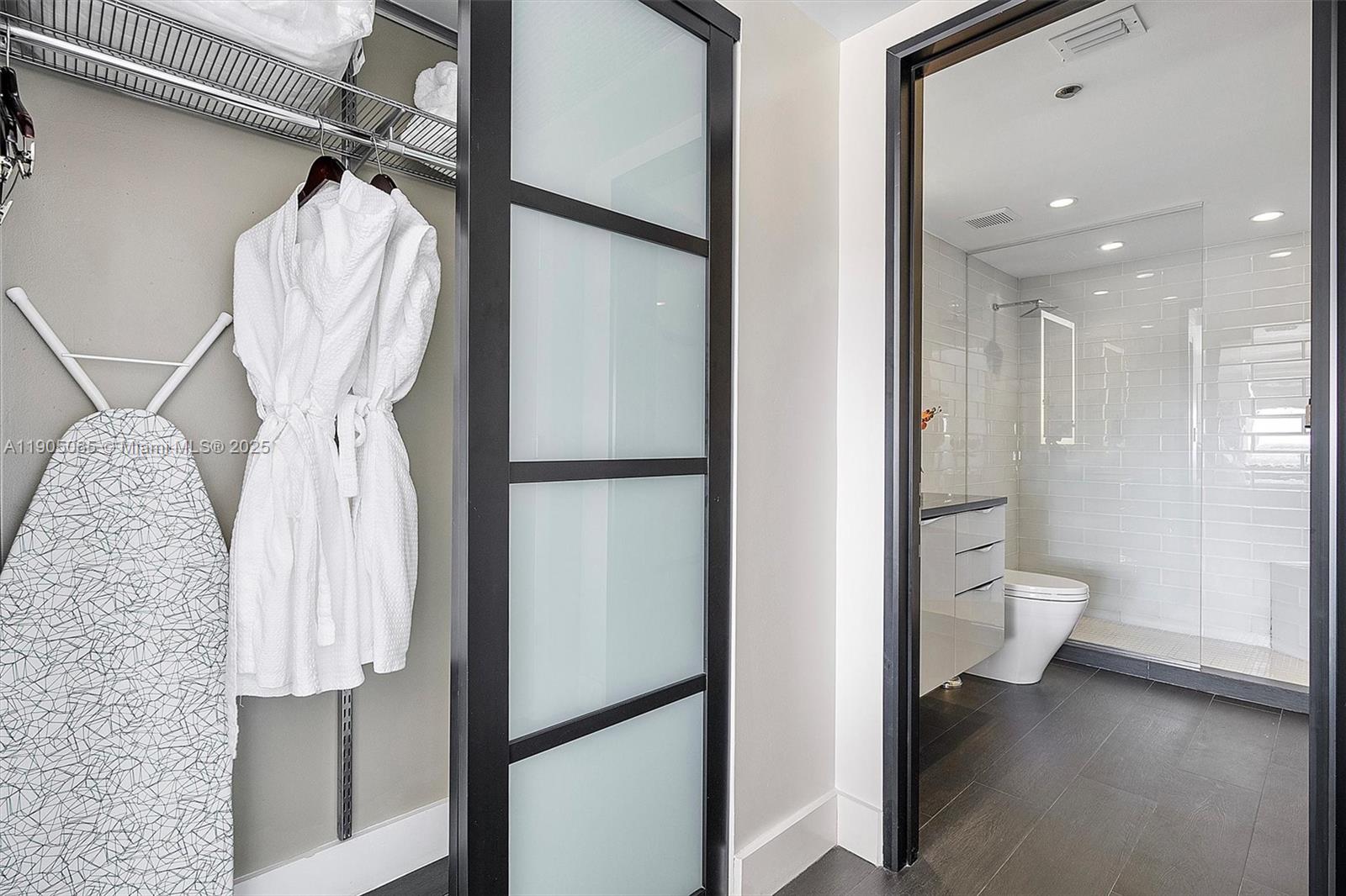 2889 McFarlane Road, Unit 902 Miami, FL 33133 - Photo 30 of 62 a bathroom with a toilet shower and mirror