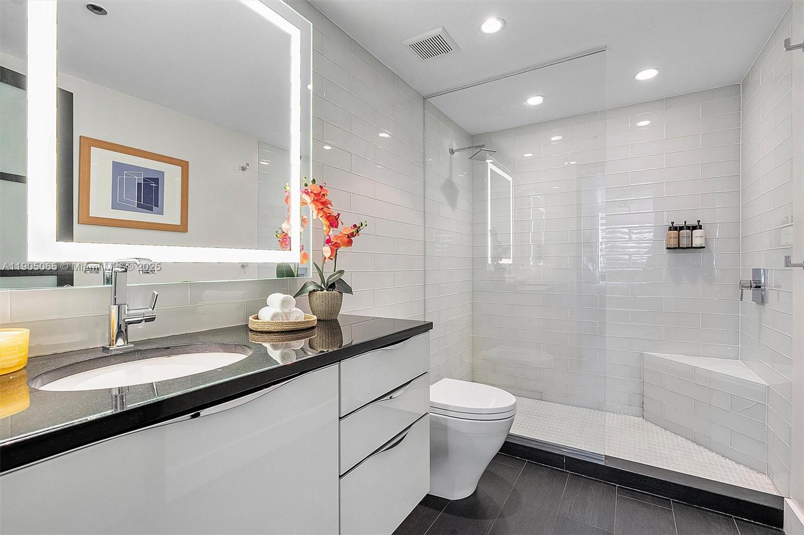 2889 McFarlane Road, Unit 902 Miami, FL 33133 - Photo 32 of 62 a bathroom with a sink a toilet and shower