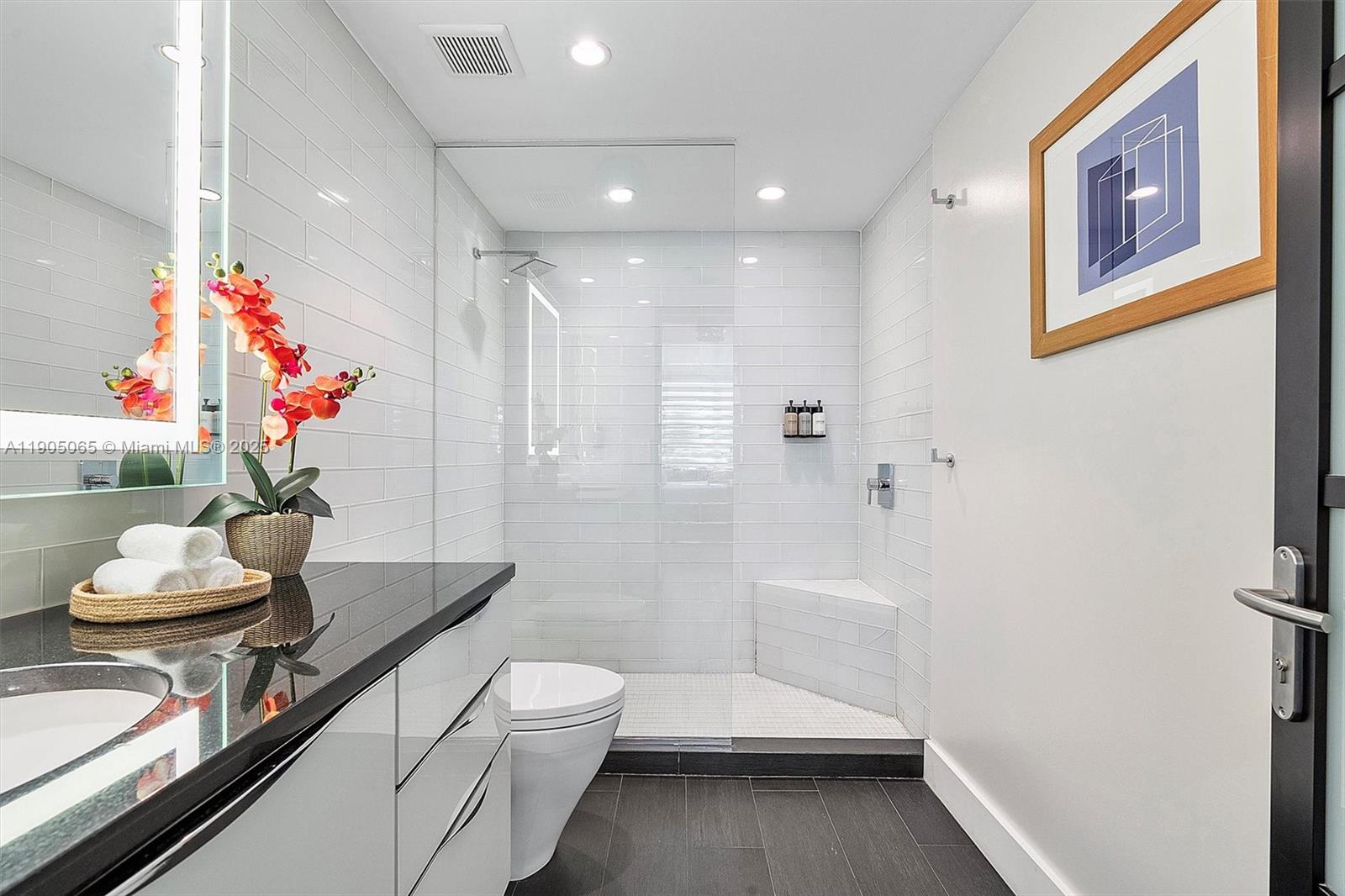 2889 McFarlane Road, Unit 902 Miami, FL 33133 - Photo 34 of 62 a bathroom with a sink a toilet and shower