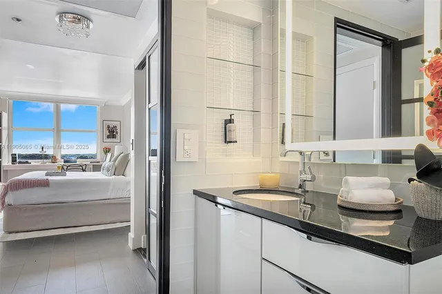 a bedroom with a bed a large window and a flat tv screen