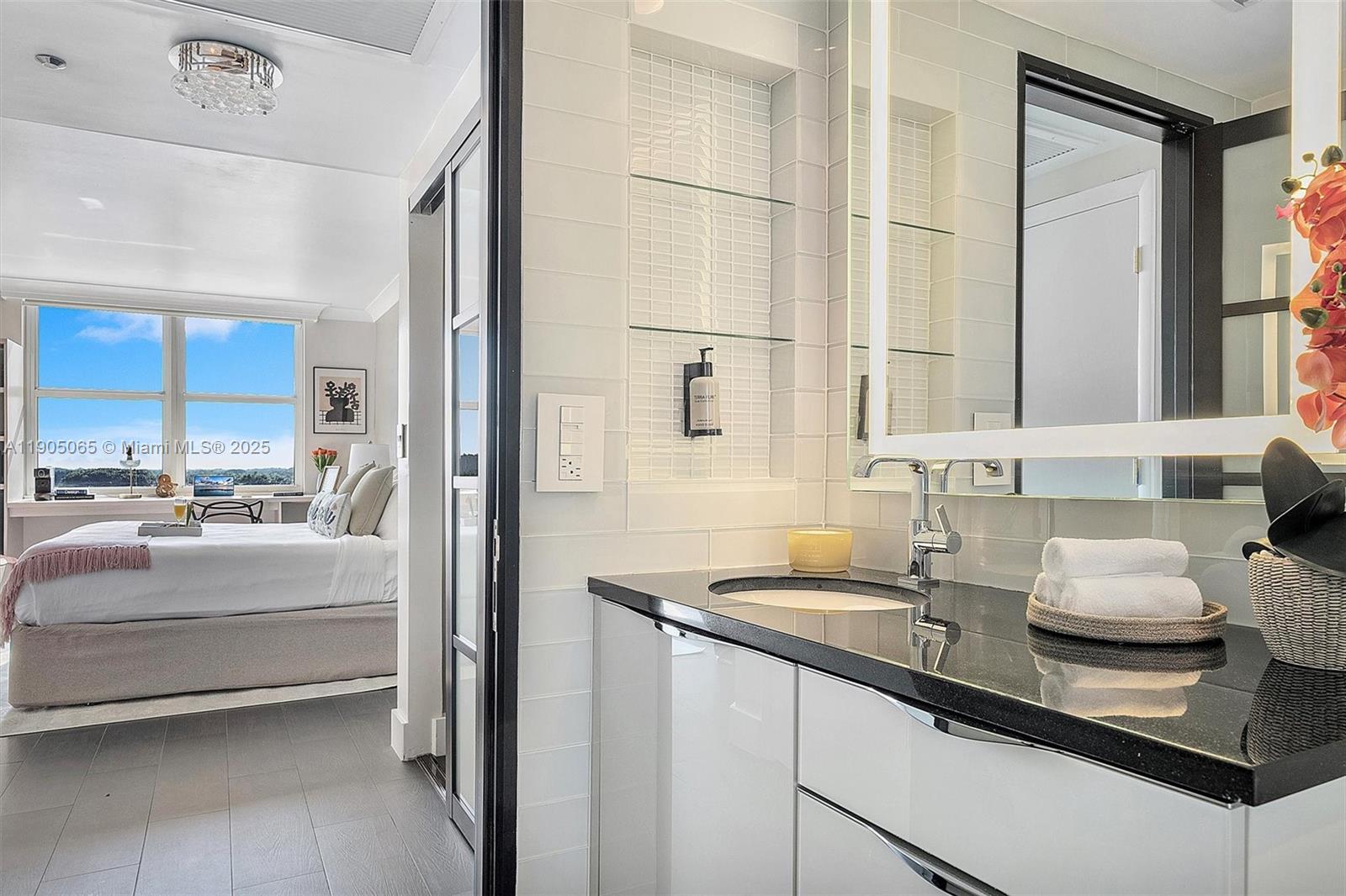 2889 McFarlane Road, Unit 902 Miami, FL 33133 - Photo 35 of 62 a bathroom with a granite countertop sink and a mirror