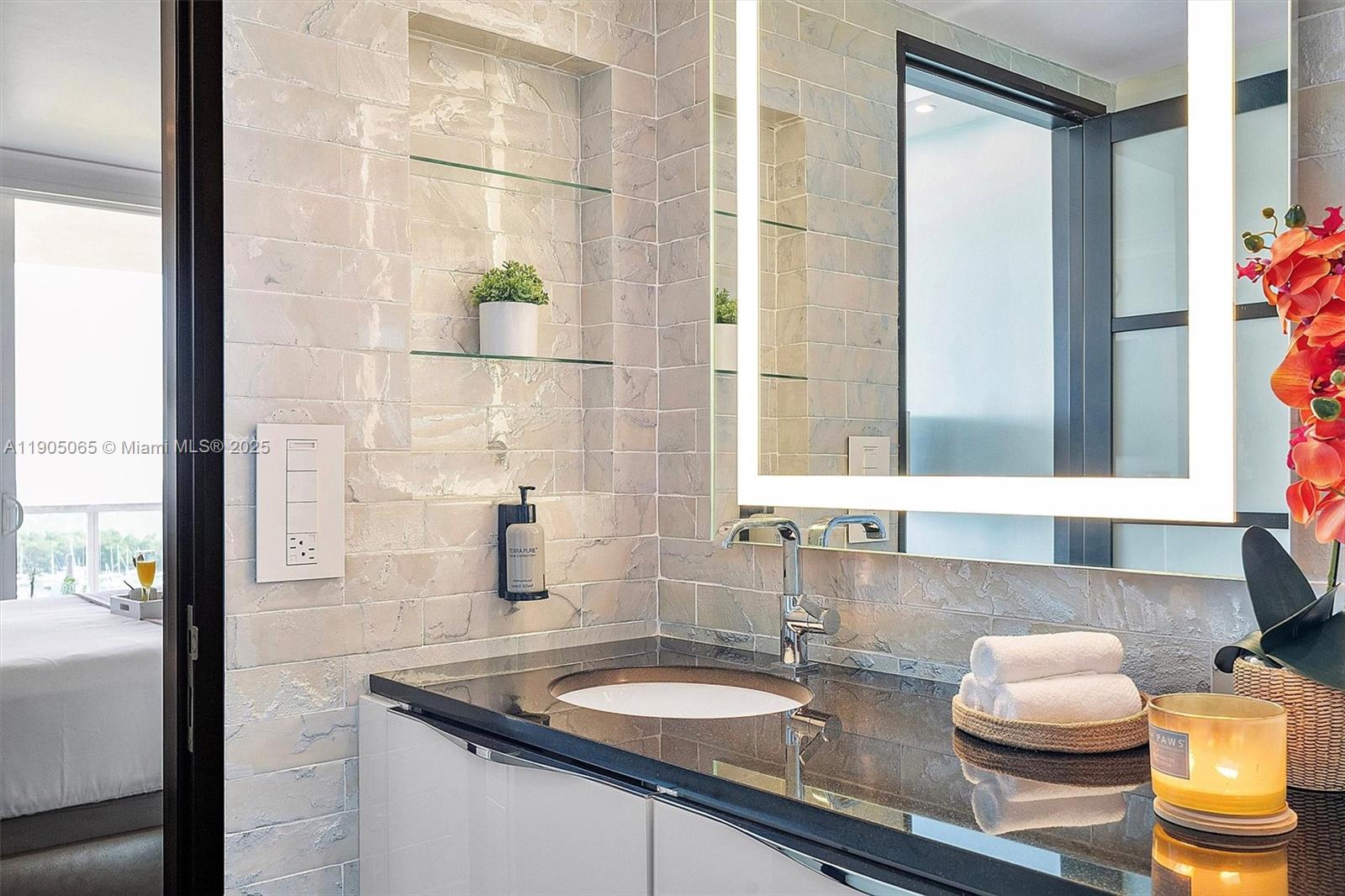 2889 McFarlane Road, Unit 902 Miami, FL 33133 - Photo 50 of 62 a bathroom with a granite countertop sink and a mirror