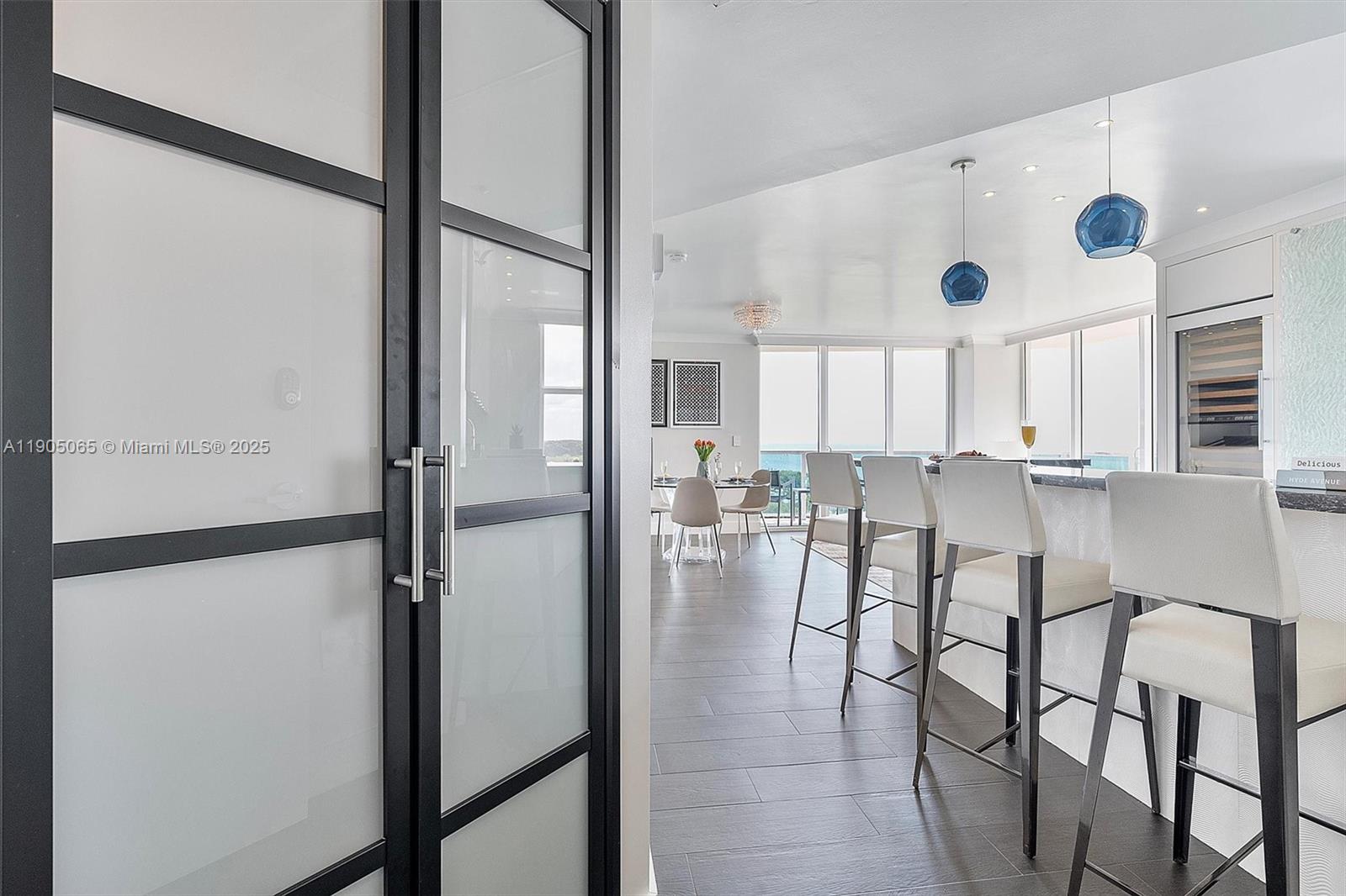 2889 McFarlane Road, Unit 902 Miami, FL 33133 - Photo 5 of 62 a kitchen with stainless steel appliances refrigerator dining table and chairs