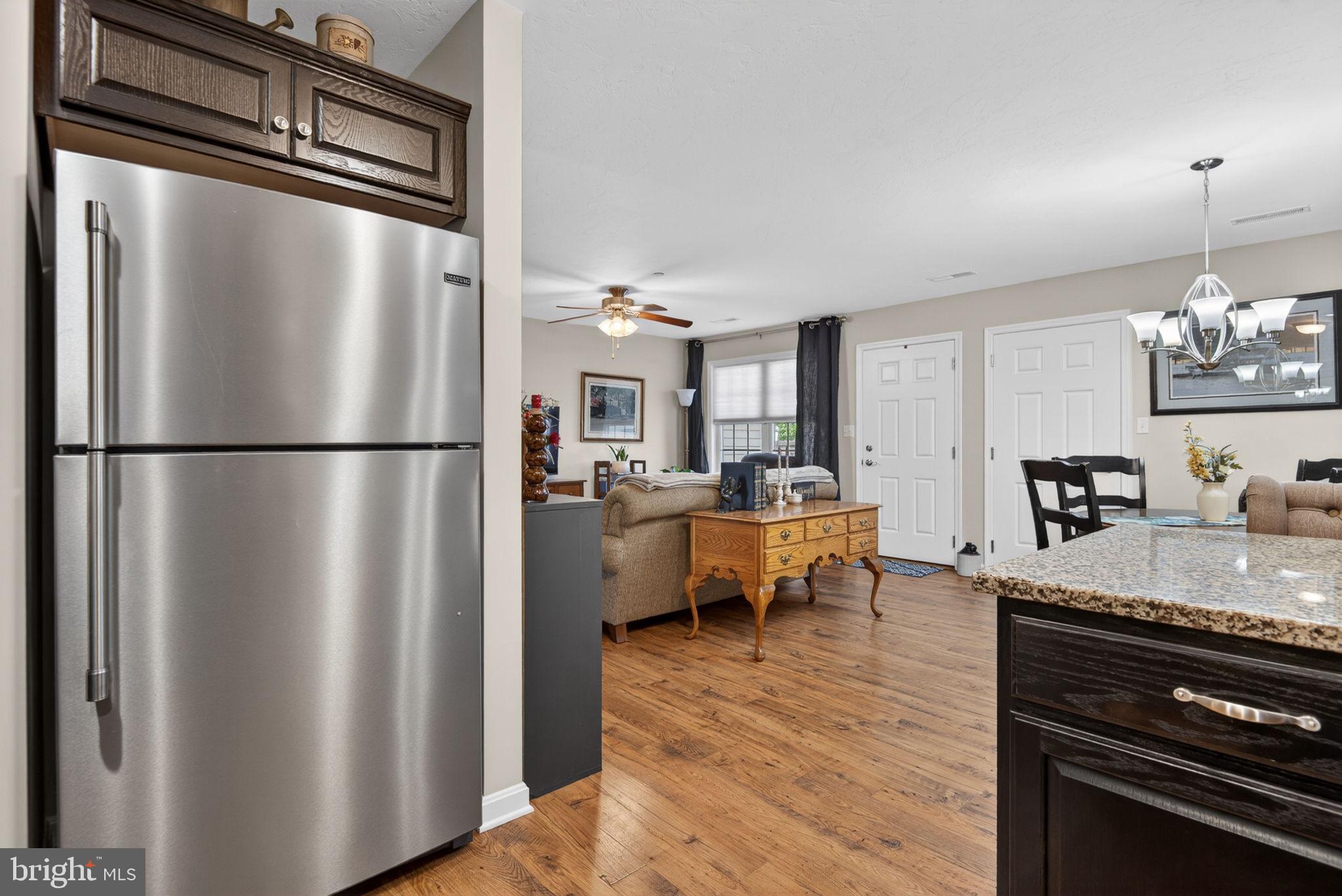 1332 Pleasant View Drive, Unit 75 Spring Grove, PA 17362 - Photo 15 of 26 a kitchen with stainless steel appliances granite countertop a refrigerator a sink dishwasher a stove and a dining table with wooden floor