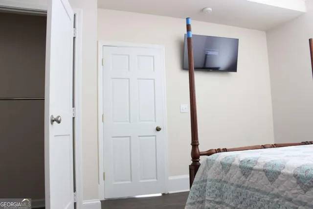 a bedroom with bed and flat tv screen