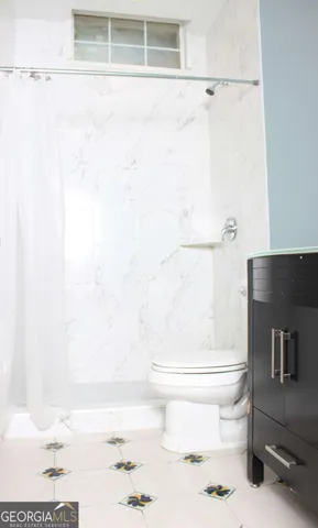 a bathroom with a toilet and a shower