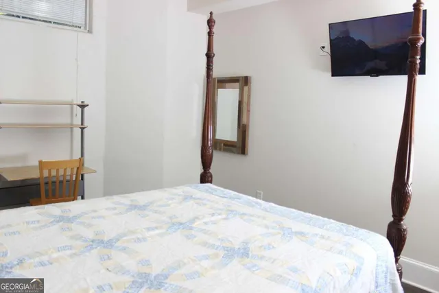 a bedroom with a bed and a flat screen tv