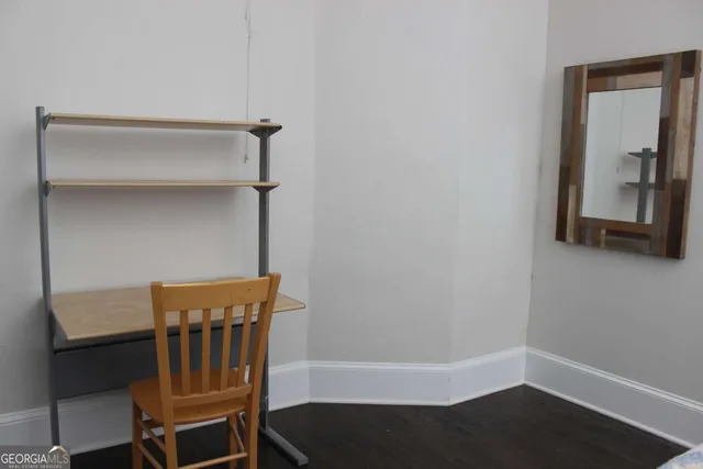 a view of a hallway with wooden floor and a cabinet