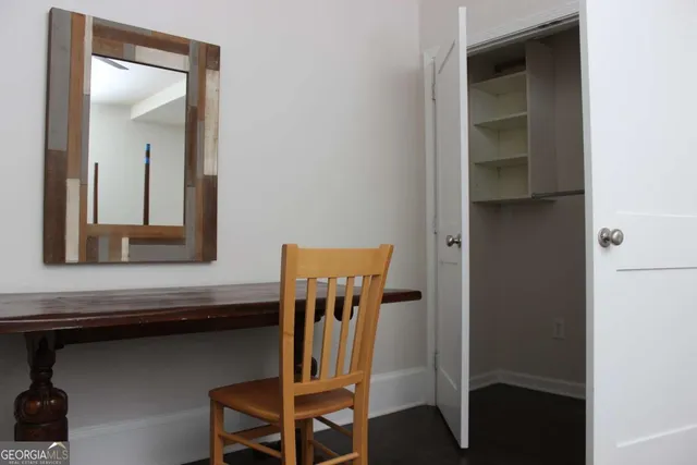 a view of hallway with chair and frames on wall