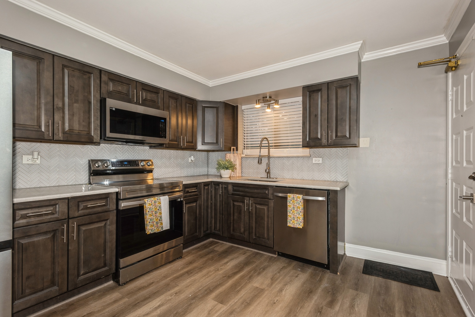 1212 Whispering Hills Court, Unit 2B Naperville, IL 60540 - Photo 5 of 10 a kitchen with stainless steel appliances granite countertop wooden cabinets a stove top oven a sink and dishwasher