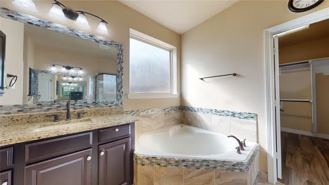 a bathroom with a granite countertop sink a large mirror and a