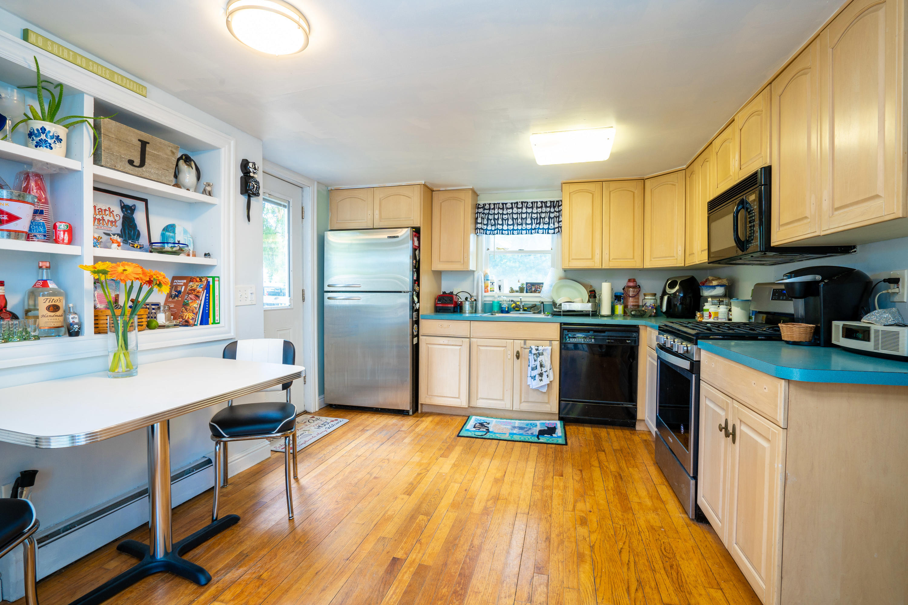 198 Adelphia Road Farmingdale, NJ 07727 - Photo 18 of 28 a kitchen with stainless steel appliances a refrigerator a stove a sink dishwasher and a dining table with wooden floor