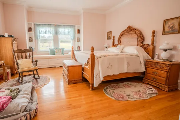 a view of a bedroom with furniture and wooden floor