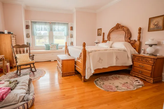 a view of a bedroom with furniture and wooden floor