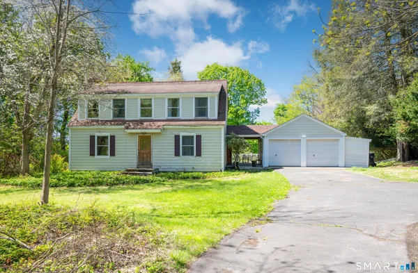a front view of house with yard and trees in the background