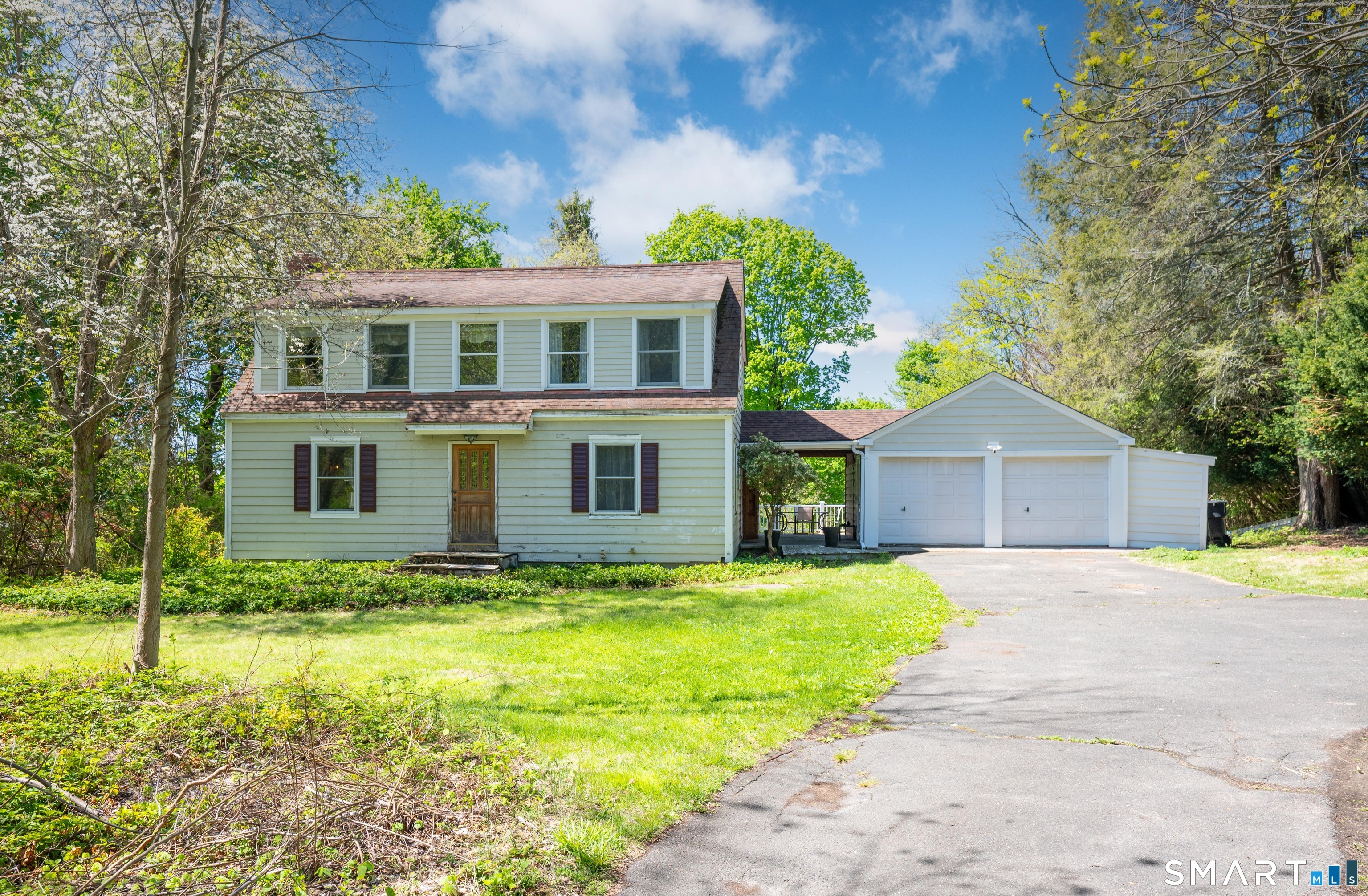 a front view of house with yard and trees in the background