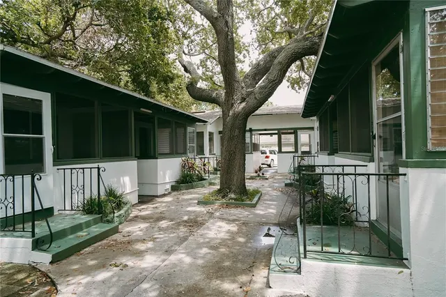 a front view of a house with a tree in front