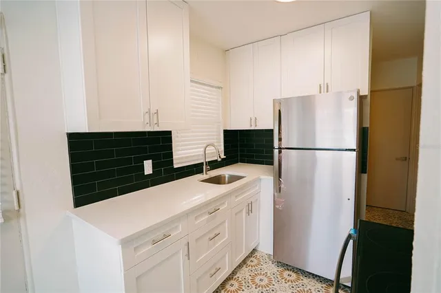 a kitchen with refrigerator and cabinets