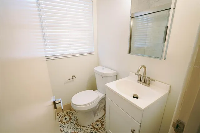 a bathroom with a sink toilet and mirror