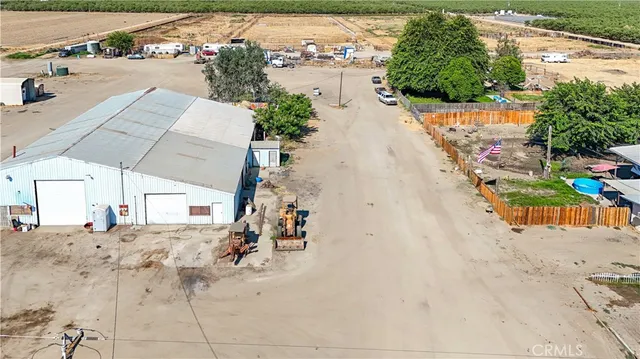 an aerial view of a house with a yard and a large tree