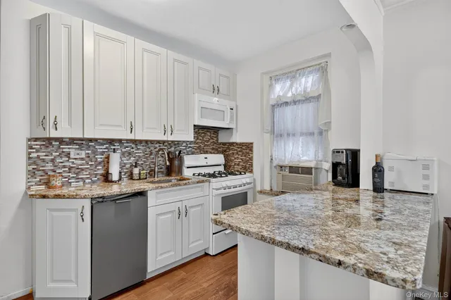 a kitchen with stainless steel appliances granite countertop a sink stove and cabinets