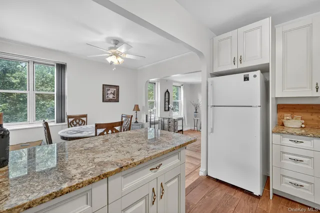 a kitchen with granite countertop a refrigerator a stove a dining table and chairs